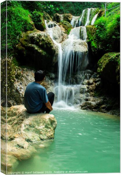 Young man enjoys the waterfall Mudal 2 Canvas Print by Hanif Setiawan