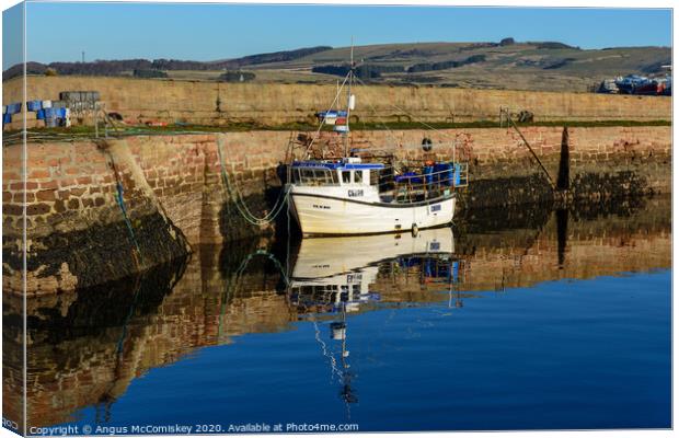 Fishing boat tied up in Cromarty harbour Canvas Print by Angus McComiskey