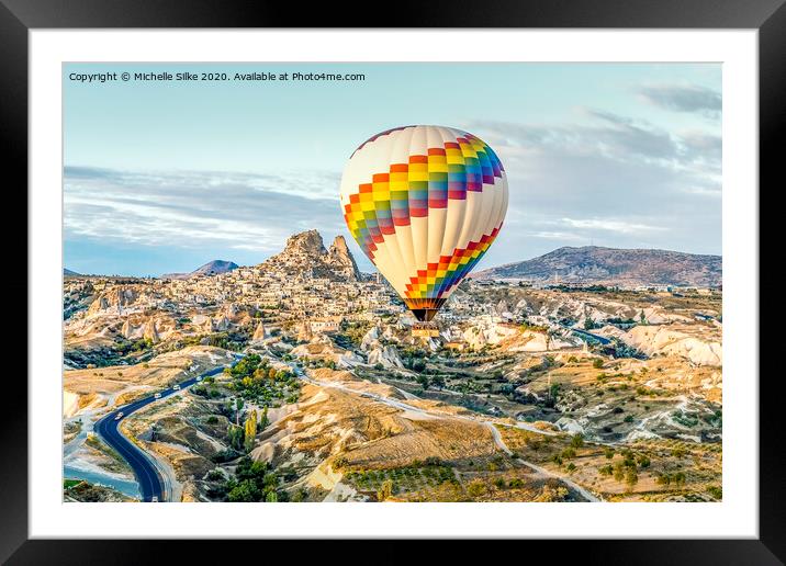 Bright single hot air balloon drifts across highways and dwarfing old town Framed Mounted Print by Michelle Silke