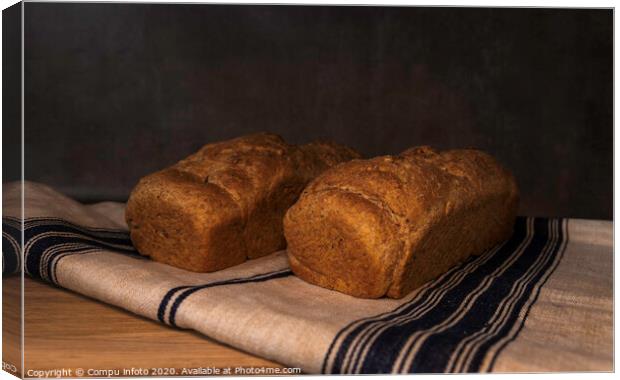 freshly baked bread on wood Canvas Print by Chris Willemsen