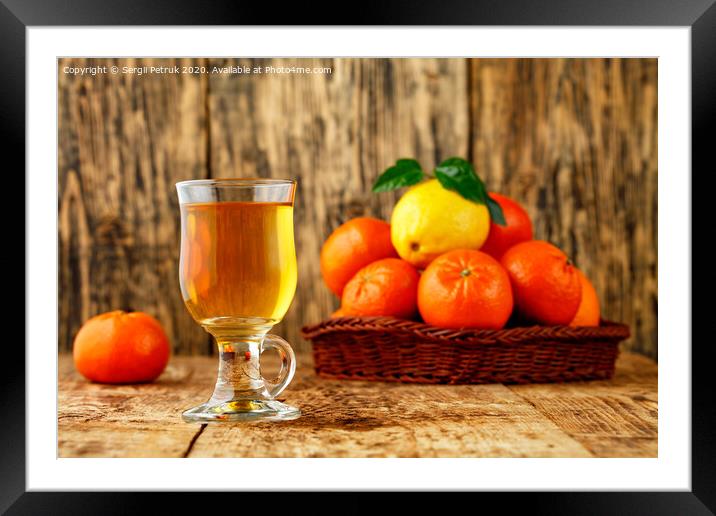 Citrus tea in a glass cup on a background of mandarin and lemon fruits in blur. Framed Mounted Print by Sergii Petruk