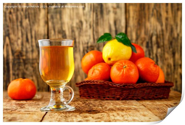 Citrus tea in a glass cup on a background of mandarin and lemon fruits in blur. Print by Sergii Petruk