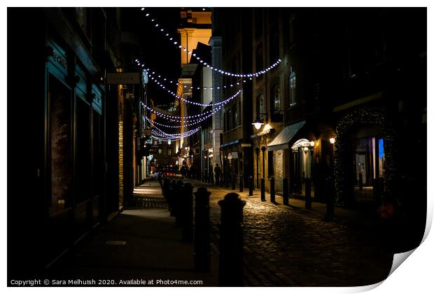 Cobblestones and Christmas lights Print by Sara Melhuish