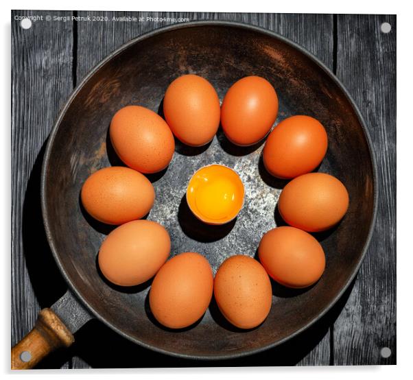 Brown chicken eggs in an old cast-iron frying pan look in the center at a broken egg with a bright yolk. Acrylic by Sergii Petruk
