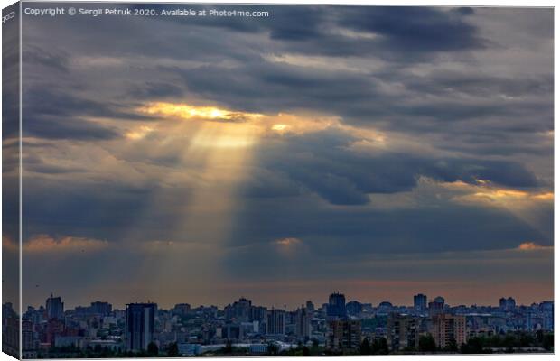 The sun's rays break through dense clouds at dawn over the city. Canvas Print by Sergii Petruk