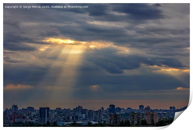 The sun's rays break through dense clouds at dawn over the city. Print by Sergii Petruk