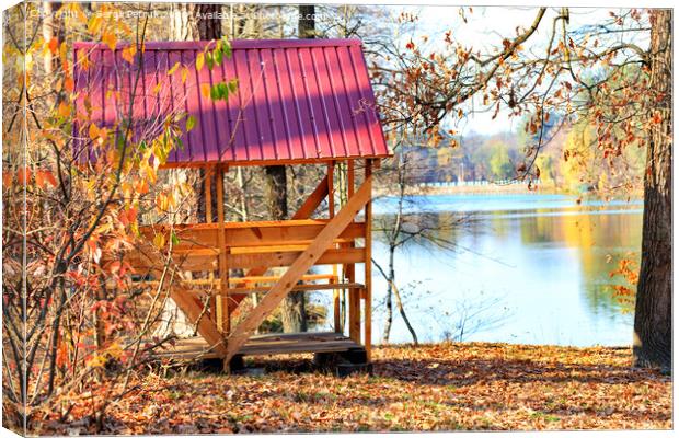 Wooden arbor with a table and picnic benches in the open air on the background of fallen leaves near a forest lake. Canvas Print by Sergii Petruk