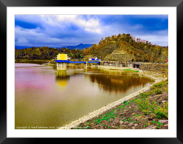 Water reservoir lake with hill, house and blue sky Framed Mounted Print by Hanif Setiawan