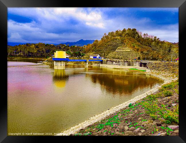 Water reservoir lake with hill, house and blue sky Framed Print by Hanif Setiawan