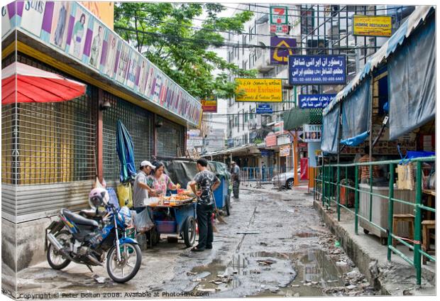 A side street in central Bangkok, Thailand, after heavy rain. Canvas Print by Peter Bolton