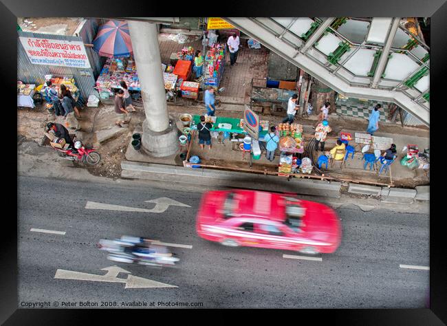 Overhead view of a street with food vendors and traffic speeding past. Bangkok, Thailand. Framed Print by Peter Bolton