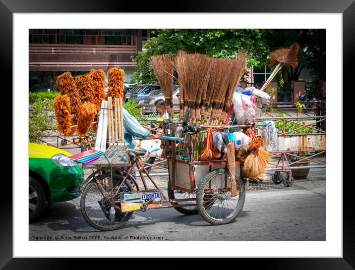 Mobile street vendor selling brushes from a pedal tricycle in central Bangkok. Framed Mounted Print by Peter Bolton