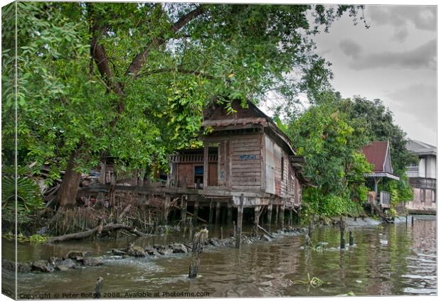 A typical dwelling on one of the canals off the Chao Phraya river, Bangkok. Canvas Print by Peter Bolton