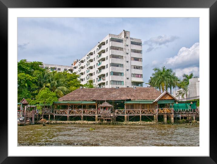 Traditional  house and modern apartment block on the Chao Phraya River, Bangkok, Thailand. Framed Mounted Print by Peter Bolton