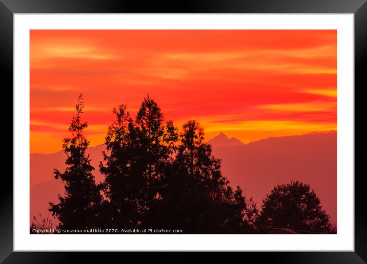 a spectacular sunset over the mountains paints the Framed Mounted Print by susanna mattioda