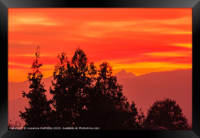 a spectacular sunset over the mountains paints the Framed Print by susanna mattioda