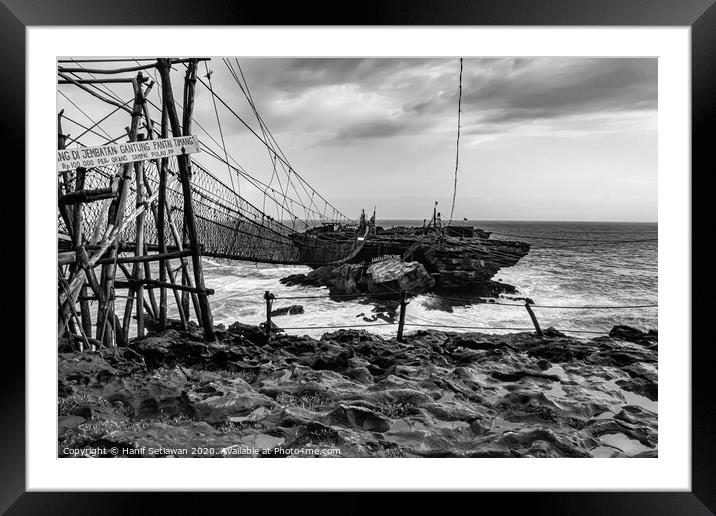 Rope foot bridge from plateau to rock island Framed Mounted Print by Hanif Setiawan