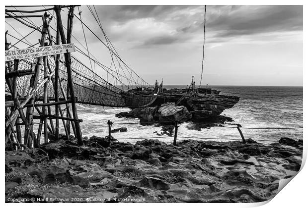 Rope foot bridge from plateau to rock island Print by Hanif Setiawan