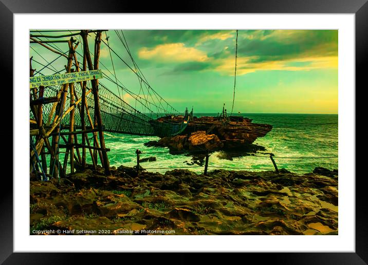 Challenge on a rope foot bridge to a rock island. Framed Mounted Print by Hanif Setiawan