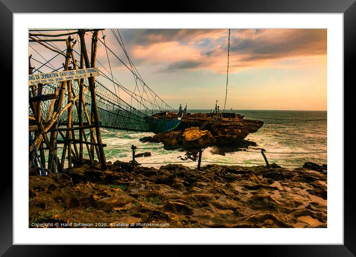 Rock island connected by rope foot bridge Framed Mounted Print by Hanif Setiawan