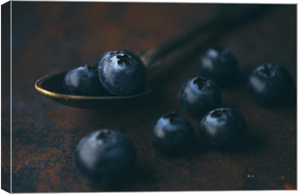 Fresh blueberry in a teaspoon on a rough surface Canvas Print by Tartalja 