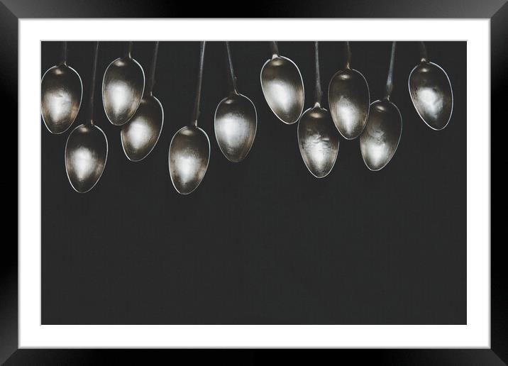 A row of silver tea spoons laying on canvas cloth, background Framed Mounted Print by Tartalja 