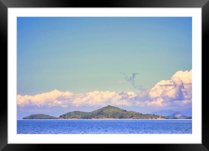 island with a clear blue sky background Framed Mounted Print by John Lusikooy