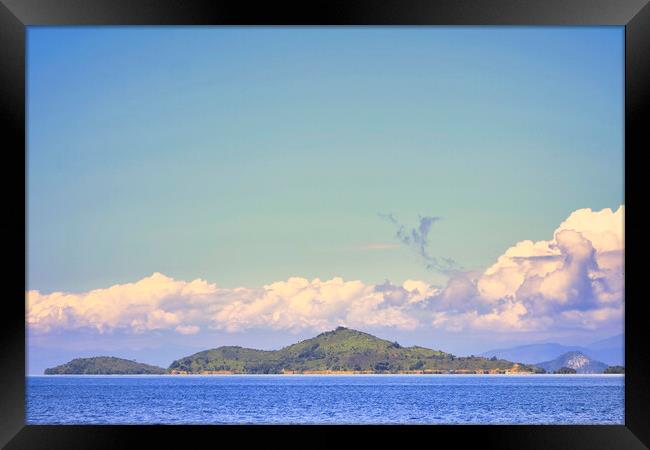 island with a clear blue sky background Framed Print by John Lusikooy