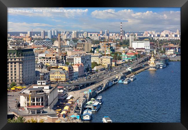 The landscape of summer Kyiv with a view of the Dnipro embankment in the old Podol district, piers and pleasure boats. Framed Print by Sergii Petruk