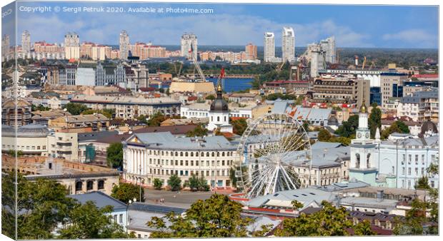 The landscape of the summer city of Kyiv overlooking the old district of Podil with a Ferris wheel and a bell tower with a gilded dome, the Dnipro River and many city buildings. Canvas Print by Sergii Petruk