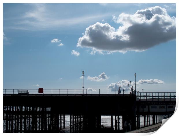Part of the walkway in silhouette at Southend Pier, Essex, UK, with isolated clouds overhead. Print by Peter Bolton