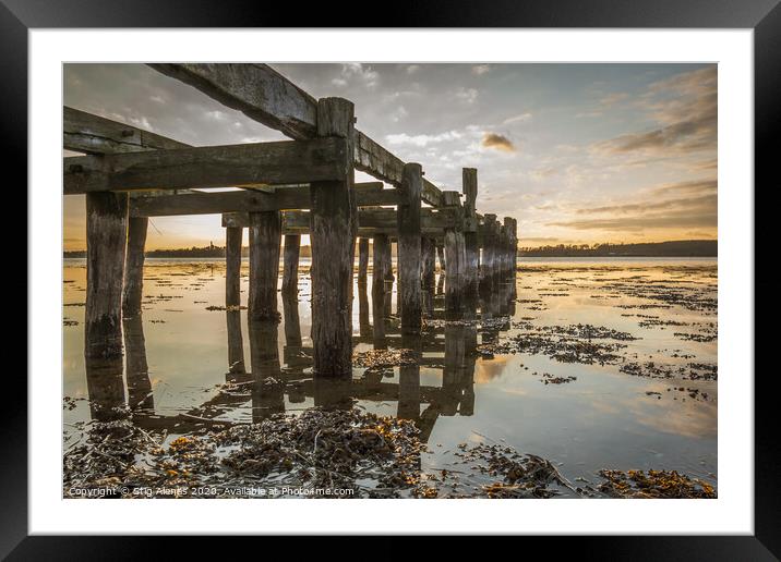 Old wooden jetty with poles reflecting in the water Framed Mounted Print by Stig Alenäs