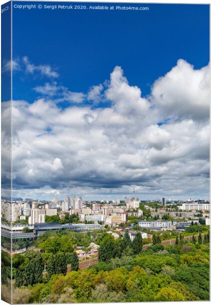 An urban landscape with a green park, residential areas and a TV tower against a bright blue sky with thickening clouds. Canvas Print by Sergii Petruk