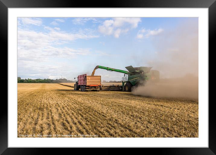 Combine harvester drains its grain in a tractor Framed Mounted Print by Stig Alenäs