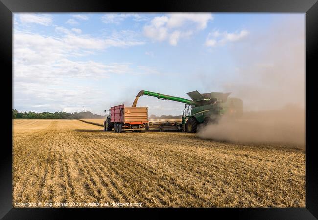 Combine harvester drains its grain in a tractor Framed Print by Stig Alenäs