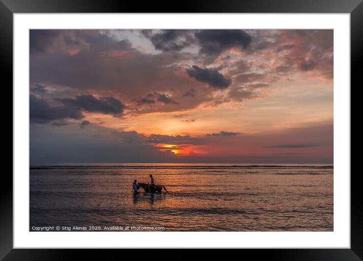 Woman riding a horse in shallow water at sunset  Framed Mounted Print by Stig Alenäs