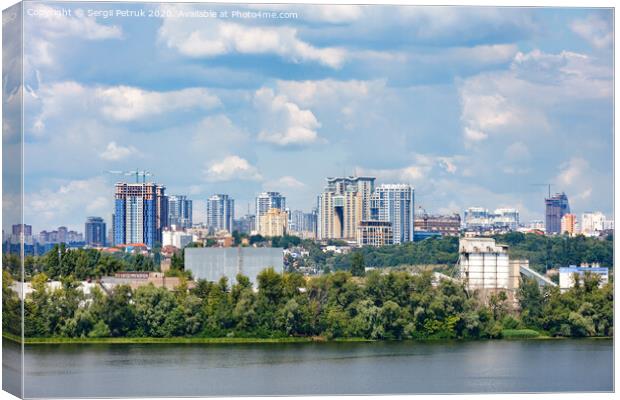 The beautiful cityscape of Kyiv with the Dnipro River, an industrial complex on the bank and new high-rise buildings on the horizon. Canvas Print by Sergii Petruk