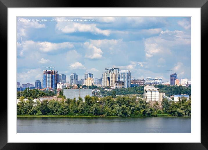 The beautiful cityscape of Kyiv with the Dnipro River, an industrial complex on the bank and new high-rise buildings on the horizon. Framed Mounted Print by Sergii Petruk