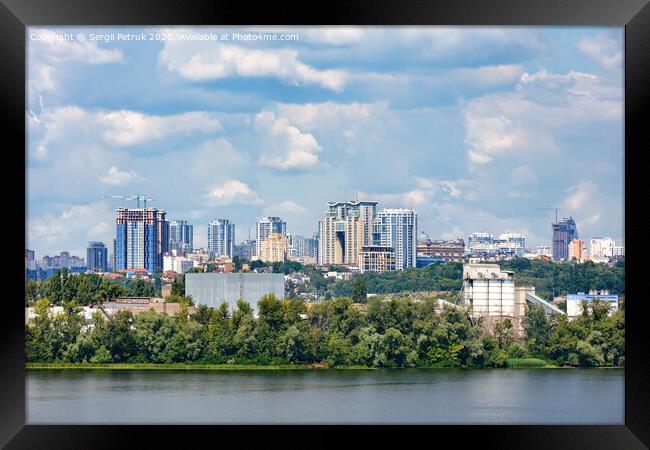 The beautiful cityscape of Kyiv with the Dnipro River, an industrial complex on the bank and new high-rise buildings on the horizon. Framed Print by Sergii Petruk