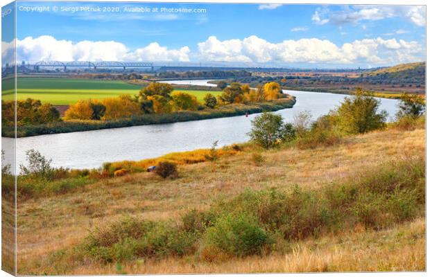 A beautiful autumn landscape with a smooth bend of the river among the plain of fields. Canvas Print by Sergii Petruk