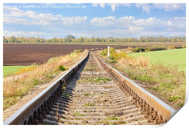 A single railroad track with a bend among the fields against the backdrop of a rural landscape. Print by Sergii Petruk