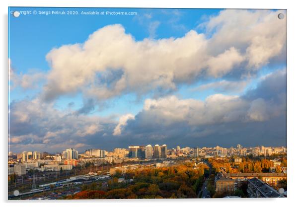 The colorful cityscape of autumn Kyiv, the sun's rays from behind gray clouds catch and brightly illuminate the orange foliage of the city park. Acrylic by Sergii Petruk