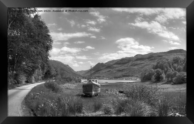 Boat near mountain road and lake in Scotland Framed Print by Philip Brown