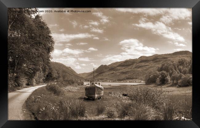Boat near mountain road and lake in Scotland Framed Print by Philip Brown