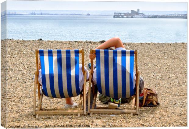 A couple on the beach in deckchairs silhouetted through the canvas at Southend on Sea, Essex, UK. Canvas Print by Peter Bolton