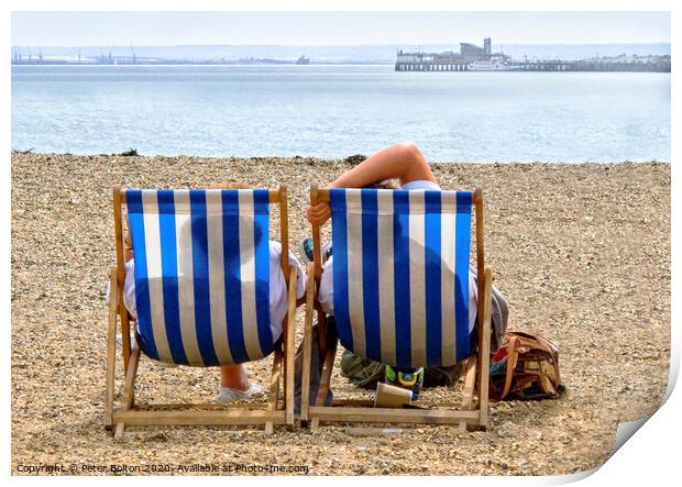 A couple on the beach in deckchairs silhouetted through the canvas at Southend on Sea, Essex, UK. Print by Peter Bolton
