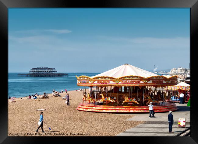 A merry-go-round on Brighton Beach on a summer day with West Pier ruins in the background. Sussex, UK. Framed Print by Peter Bolton