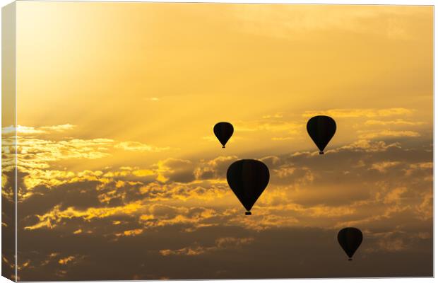 some hot air balloons in the sky with orange sunrise clouds Canvas Print by David Galindo