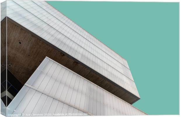 Low angle view of modern architecture glass facade against sky Canvas Print by Juan Jimenez