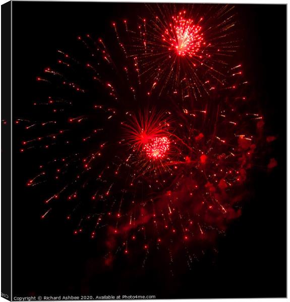Red fireworks explode Canvas Print by Richard Ashbee